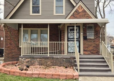 Michigan brick home with beige aluminum awning and matching railing built by Wayne Craft