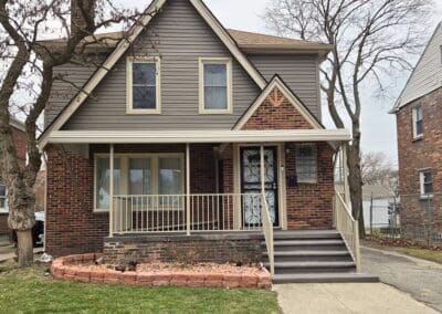 Michigan brick home with beige aluminum awning and matching railing built by Wayne Craft