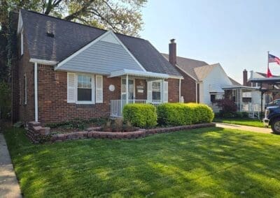 Street view of a front porch of a Michigan brick home featuring a white aluminum awning and railing built by Wayne Craft