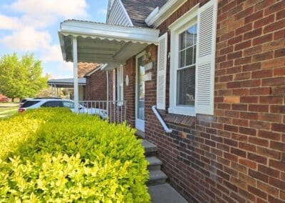 Front porch of a Michigan brick home featuring a white aluminum awning and railing built by Wayne Craft