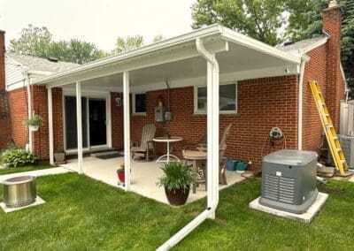 Red brick residential home with a white awning and railing built by Wayne Craft